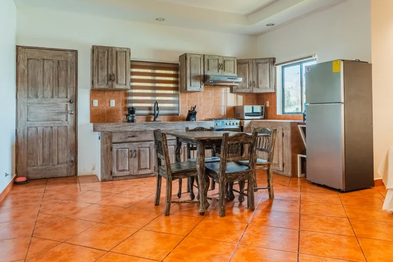 Spacious fully equipped kitchen with rustic cabinetry in a La Jolla de Guasacate apartment, Nicaragua.