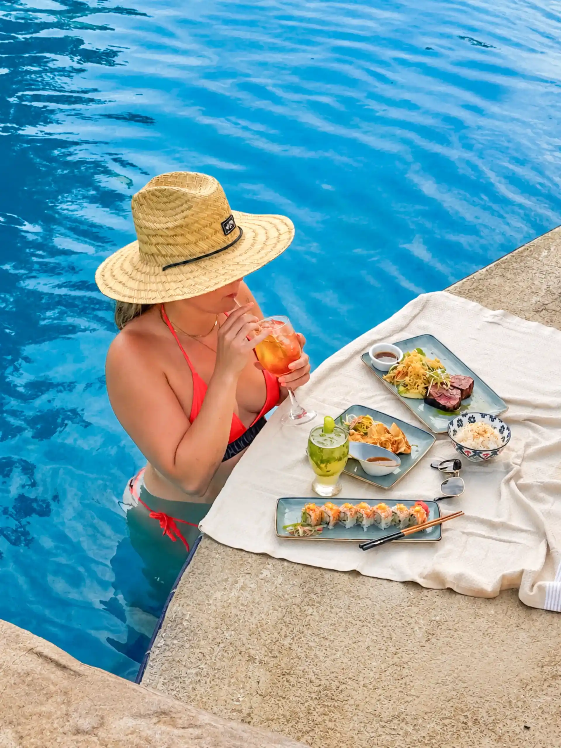 A guest enjoying gourmet food and tropical cocktails by the pool at La Jolla Nica resort in Nicaragua